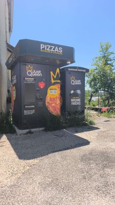 deux boîtes noires ornées de pizzas, placées devant un immeuble