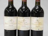 trois bouteilles de vin rouge posées côte à côte sur une table