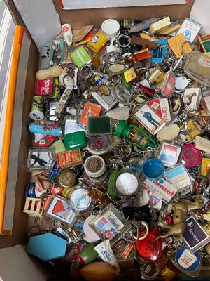 une boîte remplie d'un assortiment de porte-clés et d'autres objets