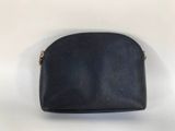 a black purse sitting on top of a table next to a white wall