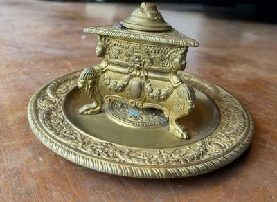a gold plate with a lid on a wooden table