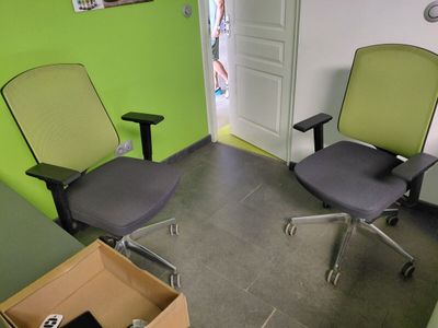 deux chaises de bureau dans une pièce dont l'un des murs est vert