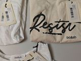 two white shirts with black writing on them sitting next to each other