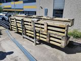 several pallets of wood are stacked on top of each other in front of a building