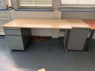 un bureau à deux tiroirs et un classeur dans un coin