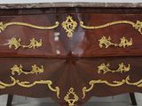 a chest of drawers with a marble top and gold decoration