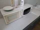 a white microwave sitting on top of a counter next to a sink