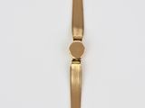 a close up of a gold bracelet on a white surface