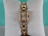 une photo d'une montre-bracelet posée sur un oreiller
