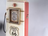 a red and white gas pump with a route 66 sign on top