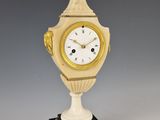 une image représentant une horloge posée sur un socle, surmontée d'une boule