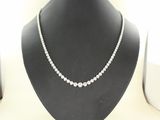 a close up of a necklace on a mannequin with a white background