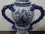 a blue and white vase with a lid on a table