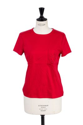 le haut rouge est posé sur un mannequin dont la base est blanche