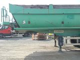 a green dump truck that is parked in a lot