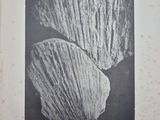 an old black and white photo of a rock with a large piece of rock in it