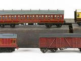 several toy trains are lined up next to each other on a white surface