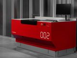 une horloge rouge posée sur un bureau dans une pièce