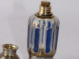 two silver and blue glass vases sitting next to each other on a white surface