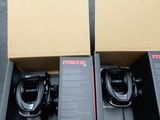 two boxes with two different types of fishing reels in them