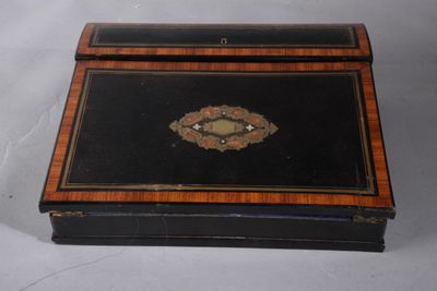 a small black box with a gold decoration on it