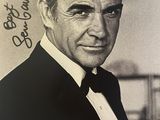 photographie en noir et blanc d'un homme en smoking tenant un pistolet