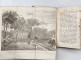 an open book with a picture of a village in the background