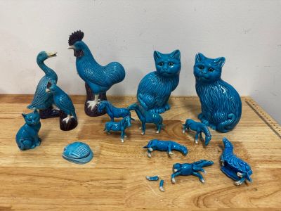 de nombreuses figurines bleues représentant des chats et des oiseaux posées sur une table