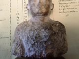 a stone statue of a man sitting on top of a table