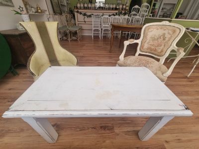 une table et des chaises blanches dans une pièce avec un parquet