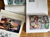 three open books on a wooden floor with drawings on them