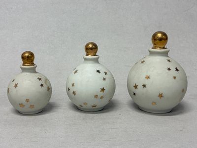 trois petites bouteilles blanches ornées d'étoiles dorées