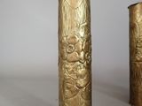 two gold vases sitting next to each other on a table