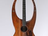 a close up of a guitar hanging on a wall