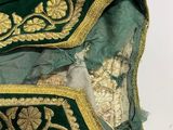 an image of a close up of a green dress with gold embroidery