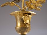 a gold vase with a plant in it on a table
