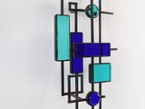 a wall mounted sculpture made of glass and metal
