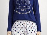 La femme porte un pyjama et un t-shirt bleu.