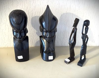 trois sculptures noires posées les unes à côté des autres sur une table