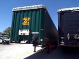 two semi trucks parked next to each other in a parking lot