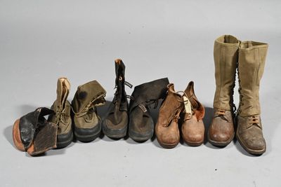Plusieurs paires de bottes sont alignées sur une surface blanche