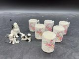 cinq tasses et une figurine de chien posées sur une table