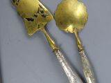 two silverwares on a table with a knife and a spoon
