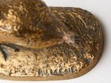 a bronze statue of a snake on a white surface