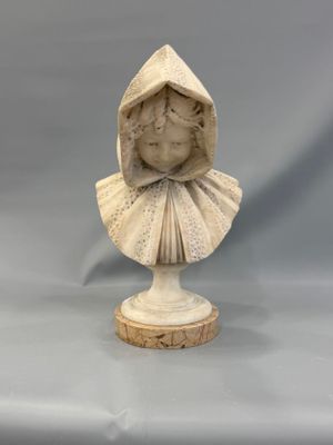un gros plan sur la statue d'une femme portant une capuche