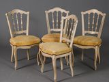 quatre chaises avec des coussins rembourrés jaunes et des pieds en bois
