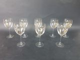 six wine glasses are lined up in a row on a table