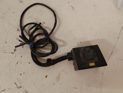 un petit appareil électronique posé par terre à côté d'un câble
