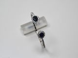 pair of sapphire and diamond rings on a white surface
