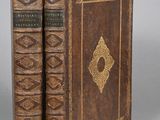 an old book sitting on top of a table next to another book